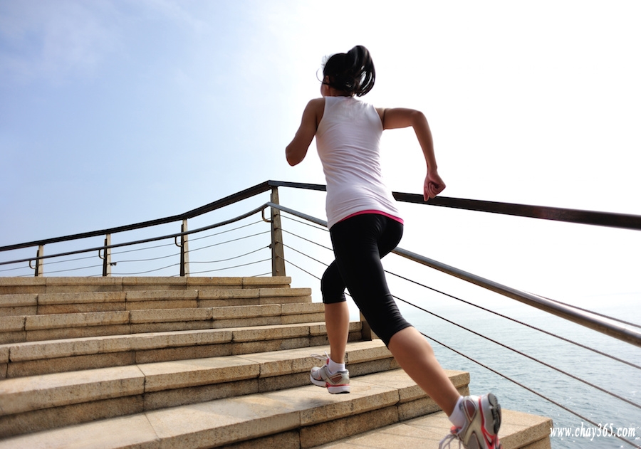 fitness woman running on stone stairs seaside